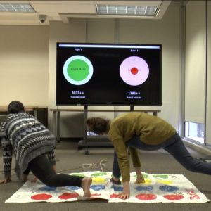Two participants playing Re-Twist, the digitally augmented version of Twister.