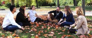 Alfrancis Guerrero, Sara Nabil, Joanie Ouellet, Alex Eady, Audrey Girouard and Lee Jones discussing during an outdoors meeting in the fall near the lab.